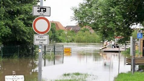 Während das Ortsschild schon fast komplett baden geht, hält sich der Hinweis darauf, dass die Fähre zwischen Mainstockheim und Albertshofen "außer Betrieb" ist, noch ganz gut über Wasser.  Foto: G. Bauer