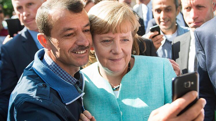 Für viele Flüchtlinge ist Angela Merkel ein Idol. Aber einen Harem auf Staatskosten bekommen sie von der Kanzlerin genauso wenig wie Taxifahrten ins Spielcasino - alles Gerüchte, die der Nürnberger Autor Jonas Lanig in seinem Faktencheck widerlegt. Foto: Bernd von Jutrczenka/dpa