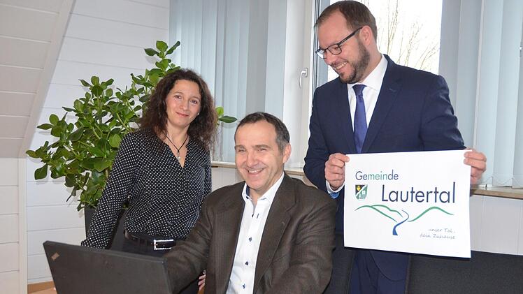 Kerstin und Klaus Kummert präsentieren gemeinsam mit Bürgermeister Sebastian Straubel (rechts) das neue Gemeindelogo. Rainer Lutz
