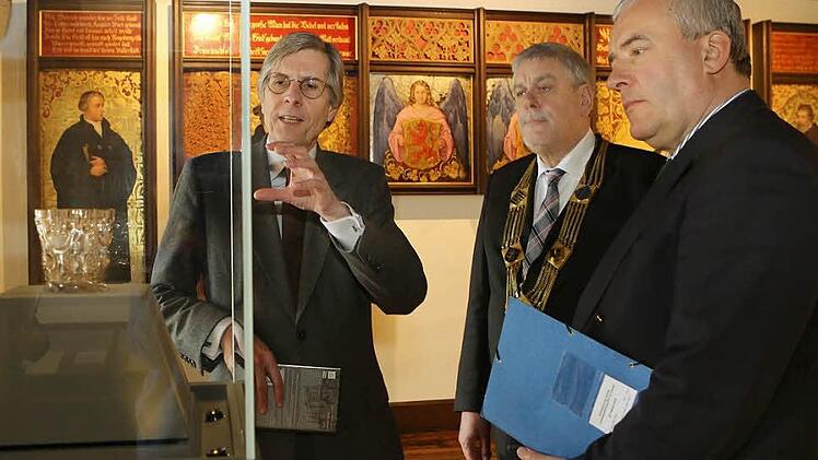 Aus diesem Becher hat Martin Luther der Überlieferung zufolge getrunken. Der Becher gehörte einst der Heiligen Elisabeth von Thüringen. Klaus Weschenfelder, Direktor der Kunstsammlungen, erläutert die Bedeutung des Bechers Oberbürgermeister Norbert Tessmer und Bayerns Kulturminister Ludwig Spaenle (CSU).  Foto: Barbara Herbst