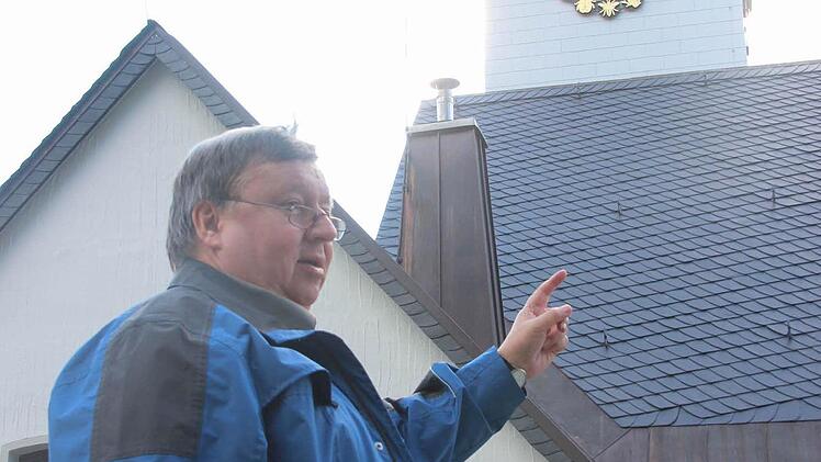 Karl Rothlauf zeigt auf die Ostseite des Kirchturms mit den Darstellungen der Tiere.  Foto: Friedwald Schedel