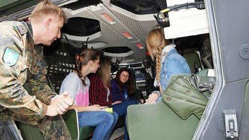 Schülerinnen nehmen im Gruppentransporter "Boxer" Platz.