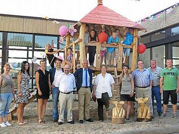 Die Hortkinder haben "ihre Burg" in Beschlag genommen und auch die offiziellen Gäste freuten sich zusammen mit den fleißigen Helfern, dass das Gemeinschaftswerk Hortspielplatz vollendet ist. Vorne sind die zwei Sitzelche zu sehen, die der Bürgermeister den Hortkindern als Gastgeschenk überreichte. Foto: Klaus-Peter Wulf