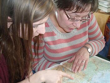 Studentin Lena Schuster und Pfarrerin Cornelia Meyer "bereisen" im Atlas die Strecke zwischen Ebrach und Odessa. Foto: Anette Schreiber