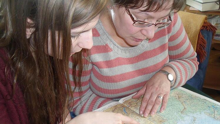 Studentin Lena Schuster und Pfarrerin Cornelia Meyer "bereisen" im Atlas die Strecke zwischen Ebrach und Odessa. Foto: Anette Schreiber