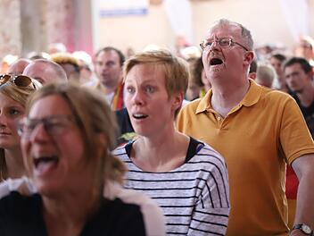 Auch der Kronacher Stadtpfarrer Thomas Teuchgräber (orangefarbenes Shirt) konnte nicht so recht glauben, was er auf der Leinwand zu sehen bekam. Foto: Marian Hamacher