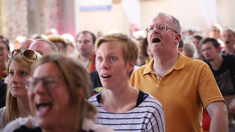 Auch der Kronacher Stadtpfarrer Thomas Teuchgräber (orangefarbenes Shirt) konnte nicht so recht glauben, was er auf der Leinwand zu sehen bekam. Foto: Marian Hamacher