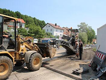 Gestern haben Mitarbeiter der Baufirma Stolz damit begonnen, den Gehweg in der Ortsmitte von Arnshausen abzufräsen und eine Ausweichstrecke für die Sanierung des Lollbaches vorzubereiten. Fotos: Ralf Ruppert
