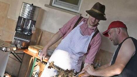 Zwei Lämmer wurden beim Sommernachtsfest am Samstagabend in Altershausen am Drehspieß gegrillt. Uwe Schmidt (rechts) und Michael Schneider zerteilten das Grillgut fachgerecht. Foto: Gerold Snater