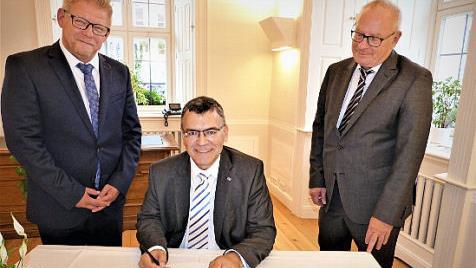 Im Beisein von B&uuml;rgermeister Frank Wilzok (links) und Kreisverkehrswacht-Vorsitzendem J&uuml;rgen Schmidt (rechts) trug sich Minister Florian Herrmann in das G&auml;stebuch der Stadt Kulmbach ein. Foto: Werner Rei&szlig;aus