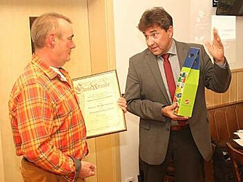 Bürgermeister Rolf Rosenbauer überreicht an Dieter Reißenweber die Ernennungsurkunde und ein Präsent.  Foto: Michael Stelzner