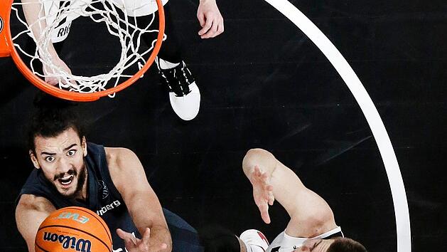 Der Bamberger Center Assem Marei hat keine M&uuml;he, den Ball in den Korb zu legen, weil die Riga-Spieler Arturs Kurucs (hinten) und Alexander Madsen (rechts) nicht energisch genug verteidigen. Foto: Daniel L&ouml;b