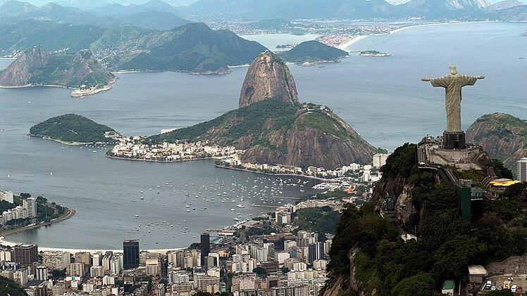 Panoramablick: Rio de Janeiro, mit der Christus-Statue im Vordergrund und dem Zuckerhut im Hintergrund.  Foto: Marcelo Sayao, dpa