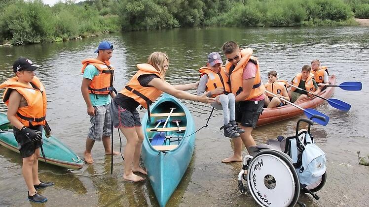 "Einer für alle - alle für einen": Der teilnehmende Rollstuhlfahrer wurde hochgehoben und ins Kanu gesetzt.  Foto: Michael Stelzner