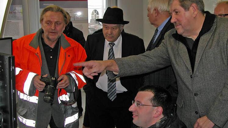 Projektpressesprecher Frank Kniestedt (links) erläutert Kommunalpolitikern am Simulator Details zur Einbindung der Neubau- in die Bestandsstrecke bei Ebensfeld.
