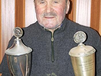 Adam Geuß mit den beiden Pokalen, die ein wenig Patina angesetzt haben. Der 76-Jährige hatte sie in den 1950er Jahren bei Abfahrtsrennen am Staffelberg gewonnen.  Fotos: Matthias Einwag