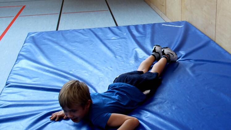 Tim legt sich auf dem Eis hin (Gewicht verteilen) und versucht, ans Ufer zu robben. Foto: Johanna Blum