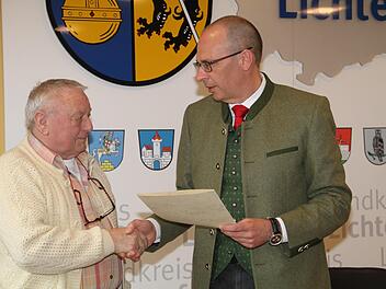 Landrat Christian Meißner (rechts) händigt an Dieter Hasenkämper aus Burgkunstadt die Pflegemedaille und die Urkunde des Landes Bayern aus. Foto: Gerda Völk