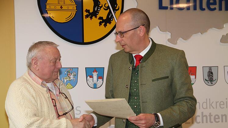 Landrat Christian Meißner (rechts) händigt an Dieter Hasenkämper aus Burgkunstadt die Pflegemedaille und die Urkunde des Landes Bayern aus. Foto: Gerda Völk