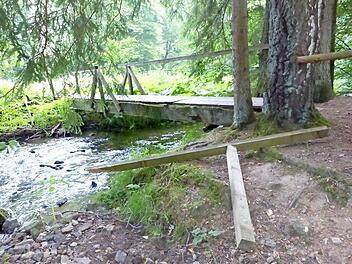 Mit brachialer Gewalt ist das Geländer der Rehbachbrücke an der Hübnersmühle abgerissen worden. Es muss jetzt von den ehrenamtlichen Kräften des Frankenwaldvereines Grafengehaig kurzfristig wieder repariert werden.  Foto: Klaus-Peter Wulf