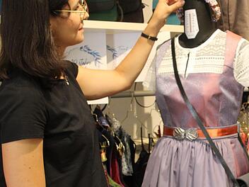Anna Jeske sucht die passenden Accessoires f&uuml;r das selbstgen&auml;hte Dirndl, rechts ihre Schwester Nora an der N&auml;hmaschine.  Fotos: Cindy D&ouml;tschel