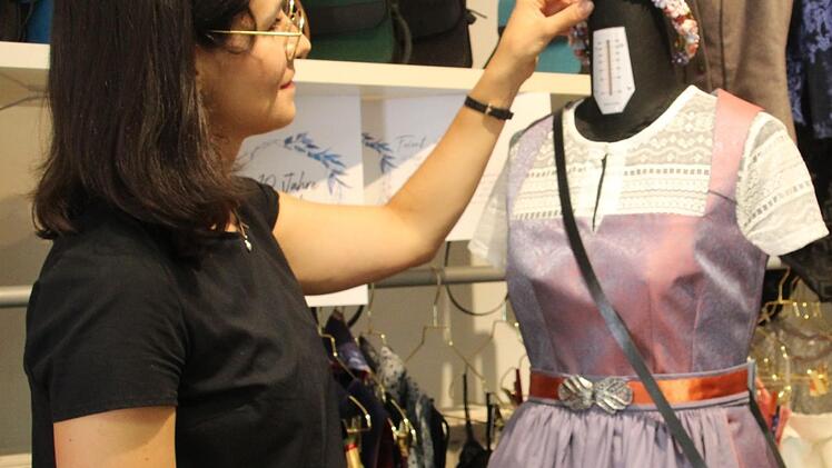 Anna Jeske sucht die passenden Accessoires f&uuml;r das selbstgen&auml;hte Dirndl, rechts ihre Schwester Nora an der N&auml;hmaschine.  Fotos: Cindy D&ouml;tschel