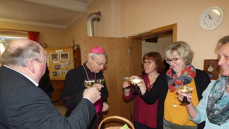 Ludwig Schick stößt mit Bürgermeister Alfons Bäuerlein und den ehrenamtlichen  Frauen auf das Kirchenjubiläum an.  Foto: Thomas Weichert