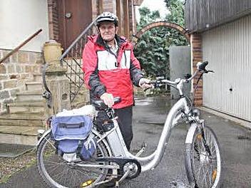 Mit Regenbekleidung, Schutzhelm und einem seinem neusten Fahrrad mit Hilfsmotor, startet Erich Heß trotz Regen und Wind zu einer 25 Kilometer langen Radtour in den Baunachgrund. Foto: Helmut Will