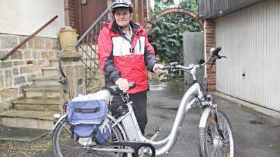 Mit Regenbekleidung, Schutzhelm und einem seinem neusten Fahrrad mit Hilfsmotor, startet Erich Heß trotz Regen und Wind zu einer 25 Kilometer langen Radtour in den Baunachgrund. Foto: Helmut Will