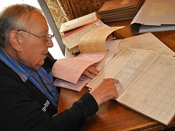 Fleischbeschauer Andreas Ort beim Schmökern in den alten Büchern, rechts die gebunden Bücher, links die neueren Blöcke mit vorgedrucktem Formular. Foto: Simon Albrecht