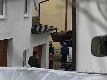 Bagger bei der Arbeit im Hinterhof. Am Montagmorgen (22.04.2013) gehen Polizei und Staatsanwaltschaft einem Hinweis nach und durchsuchen ein Haus am Marktplatz mit kleinen Garten. Der Eingang des Hauses, wo eine Leiche vermutet wird. Polizisten bewachen den Eingang. Foto: News5 / Fricke