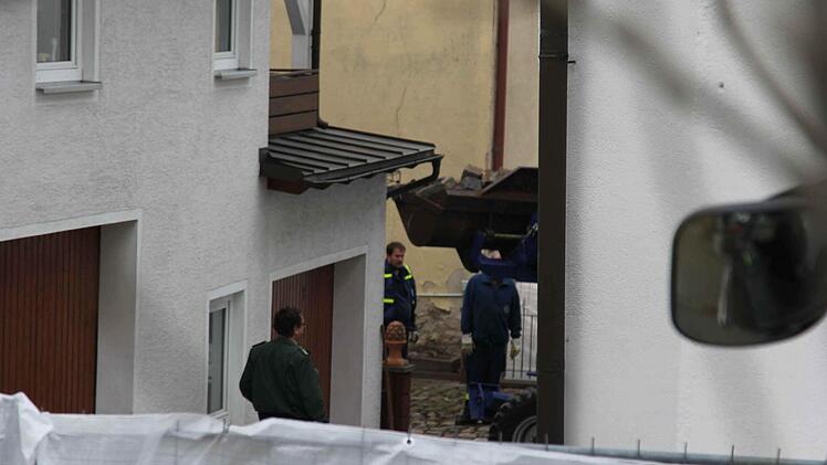 Bagger bei der Arbeit im Hinterhof. Am Montagmorgen (22.04.2013) gehen Polizei und Staatsanwaltschaft einem Hinweis nach und durchsuchen ein Haus am Marktplatz mit kleinen Garten. Der Eingang des Hauses, wo eine Leiche vermutet wird. Polizisten bewachen den Eingang. Foto: News5 / Fricke