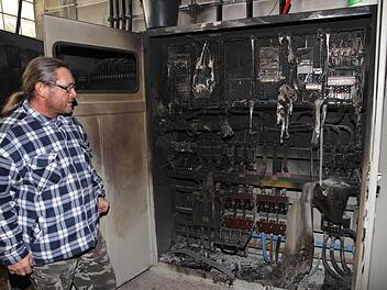 Hausmeister Wolfgang Mönius vor dem ausgebrannten Schaltschrank Foto: erl