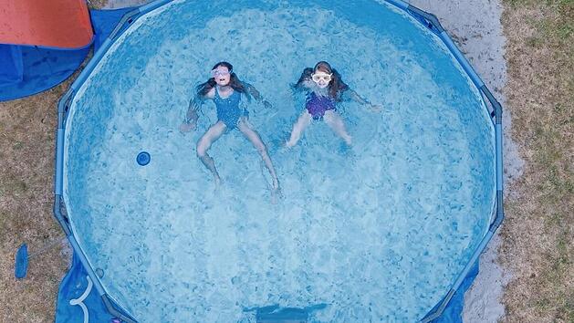 Zwei Kinder planschen in einem Pool im Garten ihres Elternhauses.  Symbolfoto: Boris Roessler, dpa
