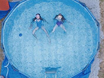 Zwei Kinder planschen in einem Pool im Garten ihres Elternhauses.  Symbolfoto: Boris Roessler, dpa