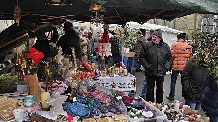 Wollhandschuhe und warme Socken und vieles mehr. Ein Besucher blickt, die Hände tief in den Jackentaschen verborgen, auf die Artikel.Helmut Will