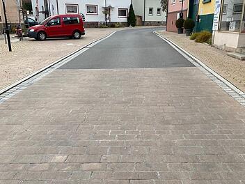 Das Bild zeigt eine der Flächen am Marktplatz, bei denen das Pflaster entfernt und durch hellen Asphalt ersetzt wird. Dadurch sollen die Abrollgeräusche der Fahrzeuge minimiert werden. Foto: Thomas Kirchner/Markt Oberthulba
