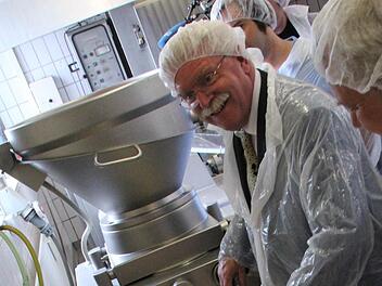 Und immer schön in die Kamera lächeln! Bayerns Wirtschaftsminister Martin Zeil (FDP) lernte gestern in Coburg, wie man Bratwurst macht.