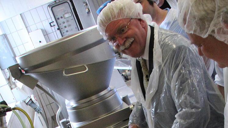 Und immer schön in die Kamera lächeln! Bayerns Wirtschaftsminister Martin Zeil (FDP) lernte gestern in Coburg, wie man Bratwurst macht.