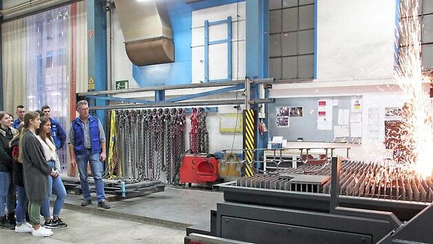 In der Abteilung Stahlbau erlebt eine Sch&uuml;lergruppe, wie man mit einer Brennschneideanlage die unterschiedlichsten Formen aus einem St&uuml;ck Stahl heraustrennen kann. Das Material verfl&uuml;ssigt sich und dabei kommt es zur Funkenbildung.  Foto: Stephan St&ouml;ckel