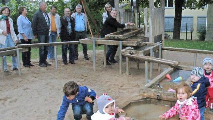 Das Wasser-Matsch-Gerät am Cortendorfer Spielplatz kommt bei den Kleinen prima an. Im Hintergrund, von links: Christiane Zinoni-Peschel, Friederike und Werner Bock, Ralf Gutgesell, Harry Wolf, Peter Klier, Zweite Bürgermeisterin Birgit Weber und der Leiter des Grünflächenamts, Bernhard Ledermann Foto: Edwin Meißinger