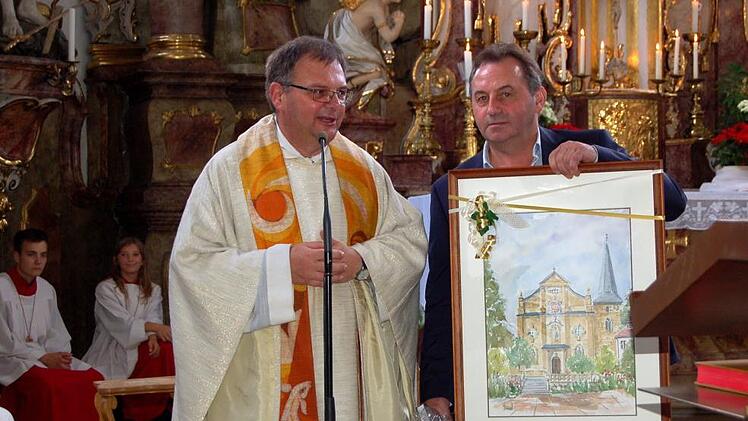 Pfarrgemeinderatsvorsitzer Johannes Schuberth überreicht Pfarrer Seel zum Abschied ein Gemälde von der Buttenheimer Pfarrkirche. Alle Fotos: Andrea Spörlein