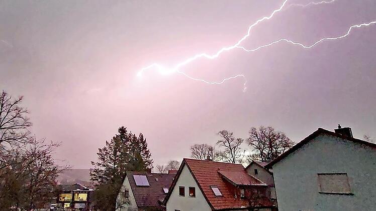 Blitze zuckten am Himmel in Münnerstadt, während der Hagel die Straßen mit einer weißen Eisschicht überzog.