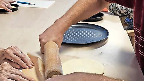 Der Pizzateig wird ausgerollt.