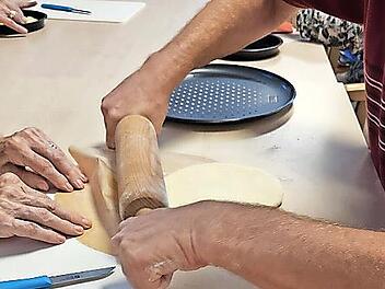 Der Pizzateig wird ausgerollt.