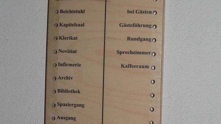 Neben der Büro-Tür von Anselm Grün hängt eine Holztafel, die zeigt, wo sich der Cellerar gerade aufhält - er ist viel unterwegs. Foto: Matthias Litzlfelder