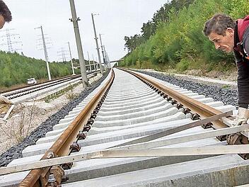 Die Bahnmitarbeiter Peter Albertz (links) und Valerie Bonda winkeln bei Wolfsberg (Thüringen) Schienen am künftigen Überholbahnhof Ilmenau-Wolfsberg der ICE-Neubaustrecke Ebensfeld-Erfurt aus. Foto: Michael Reichel/dpa