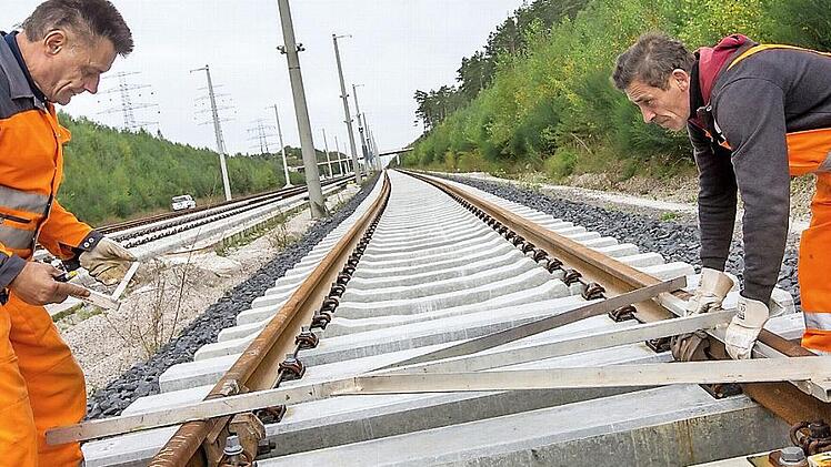 Die Bahnmitarbeiter Peter Albertz (links) und Valerie Bonda winkeln bei Wolfsberg (Thüringen) Schienen am künftigen Überholbahnhof Ilmenau-Wolfsberg der ICE-Neubaustrecke Ebensfeld-Erfurt aus. Foto: Michael Reichel/dpa