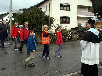 Pfarrer Richard Reis (rechts) begrüßt die Wallfahrer aus Nurn mit Weihwasser. Foto: Susanne Deuerling