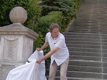 Wolfram von Bieren enthüllt den linken Handlauf am Fuße der Friedenstreppe. Foto: Petra Malbrich